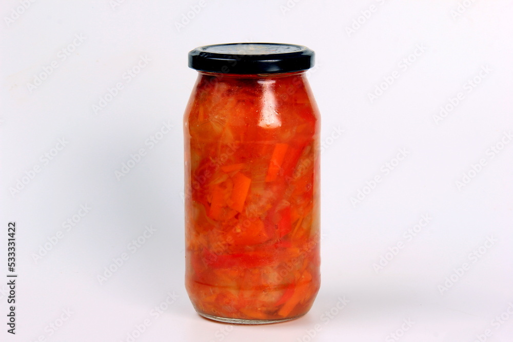 Preparation of canned lecho, canned sweet bell peppers in a glass jar on a white background. Homemade letcho with paprika, tomatoes and carrots Preparation of canned lecho, canned sweet bell peppers in a glass jar on a white background. Homemade letcho with paprika, tomatoes and carrots