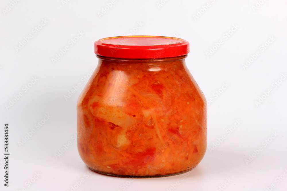 Preparation of canned lecho, canned sweet bell peppers in a glass jar on a white background. Homemade letcho with paprika, tomatoes and carrots Preparation of canned lecho, canned sweet bell peppers in a glass jar on a white background. Homemade letcho with paprika, tomatoes and carrots