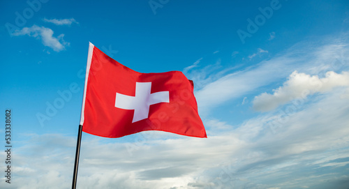 Swiss flag waving against sky photo