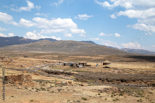 Mountain side with traditional African Lesotho huts rural out of focus with grain