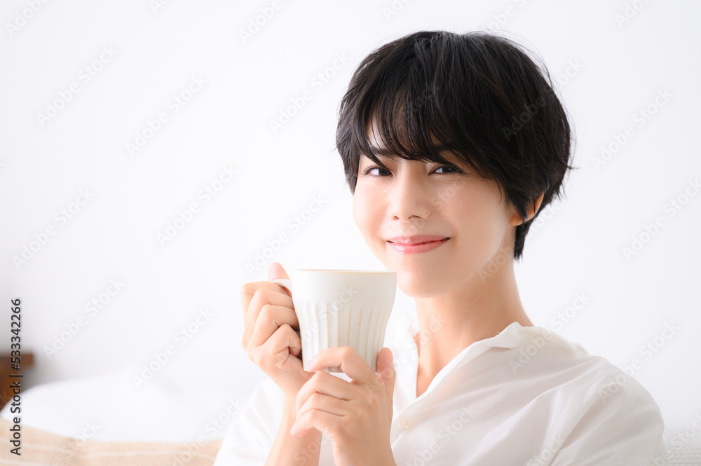Woman relaxing in her room drinking coffee or other beverages closeup Woman relaxing in her room drinking coffee or other beverages closeup