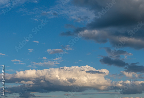 View over deep blue clean sky with illuminated clouds as a background.