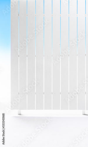 white exterior with white wooden fence and blue sky