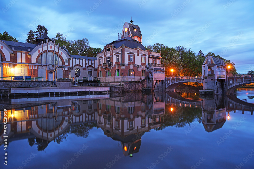 Historic hydroelectric power plant Hucak during blue hour after sunset, landmark on Labe River in Hradec Kralove, Czechia