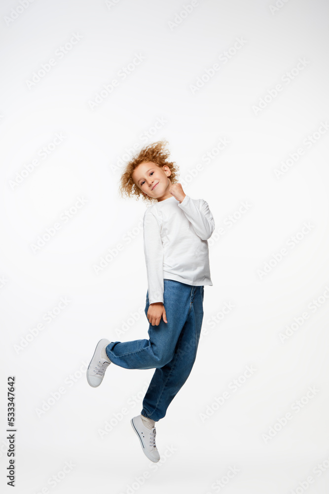 Full-length portrait of little girl, kid in white long sleeve blouse and jeans isolated over white background. Fashion, happy childhood Full-length portrait of little girl, kid in white long sleeve blouse and jeans isolated over white background. Fashion, happy childhood