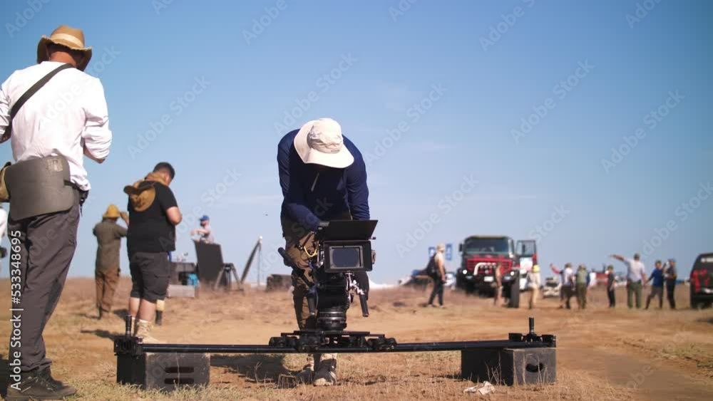 Filming in the steppe. The operator moves the video camera along the slider. Film crew Filming in the steppe. The operator moves the video camera along the slider. Film crew