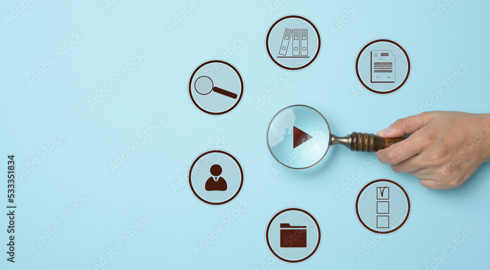 Control and effective management in the company, a female hand holds a magnifying glass Control and effective management in the company, a female hand holds a magnifying glass
