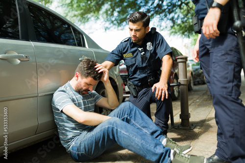 Cops helping an injured man after a car crash Fototapet
