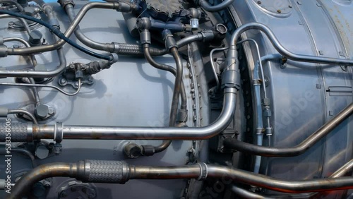 A close-up of a rocket engine with multiple pipelines supplying fuel and coolant to the combustion chamber. Jet engine with many titanium and stainless steel parts. Engine for military missiles.