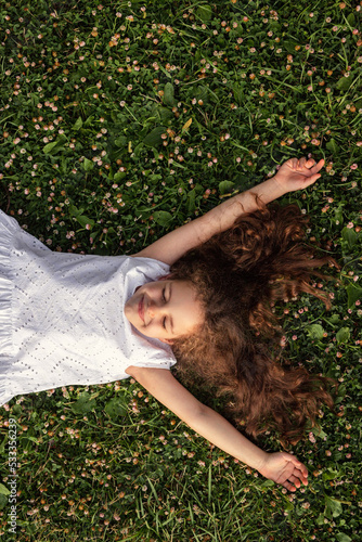 Happy girl lying on green grass