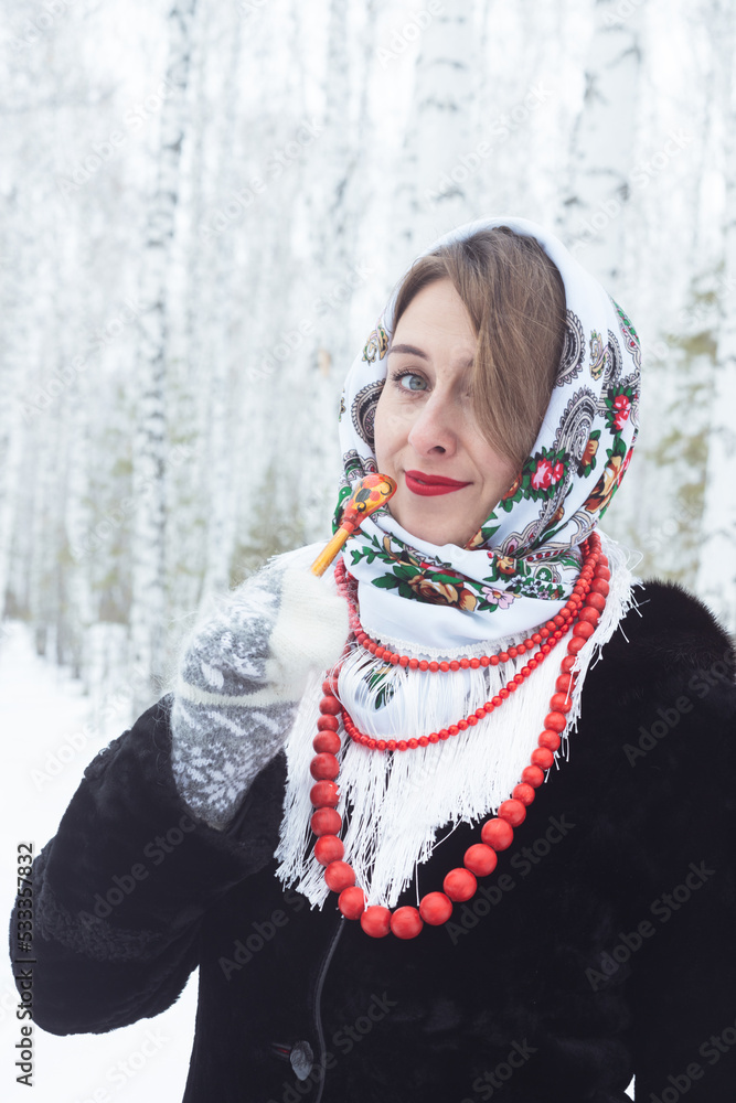 A girl in a winter forest. A beautiful woman in a fur coat at a covered table among the birches A girl in a winter forest. A beautiful woman in a fur coat at a covered table among the birches