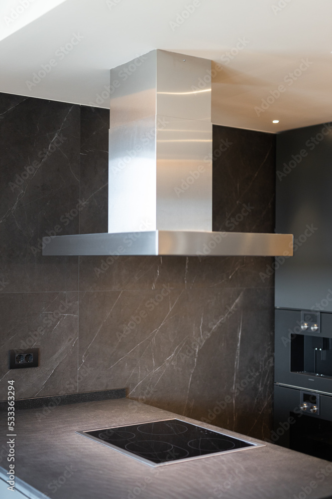 Kitchen interior with induction stove and stainless steel exhaust Kitchen interior with induction stove and stainless steel exhaust