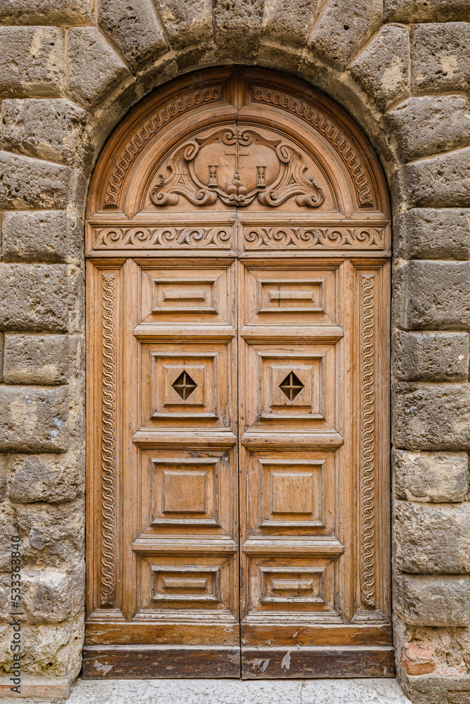 Walking Urbino city streets. Close up view of beautiful ancient wooden door Walking Urbino city streets. Close up view of beautiful ancient wooden door