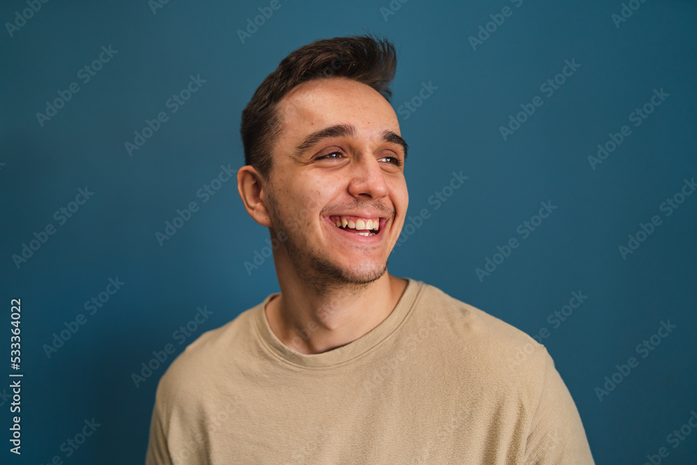 Portrait of a man standing in front of a blue background Portrait of a man standing in front of a blue background