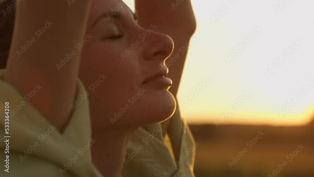 Close-up of a woman's face at sunset relaxing, breathing in fresh air, doing yoga. Close-up of a woman's face at sunset relaxing, breathing in fresh air, doing yoga.