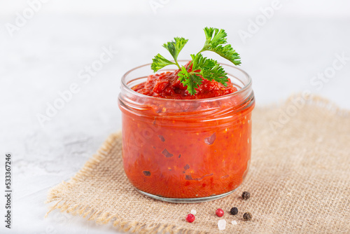 Paste ajvar from sweet pepper and spices on a light background.