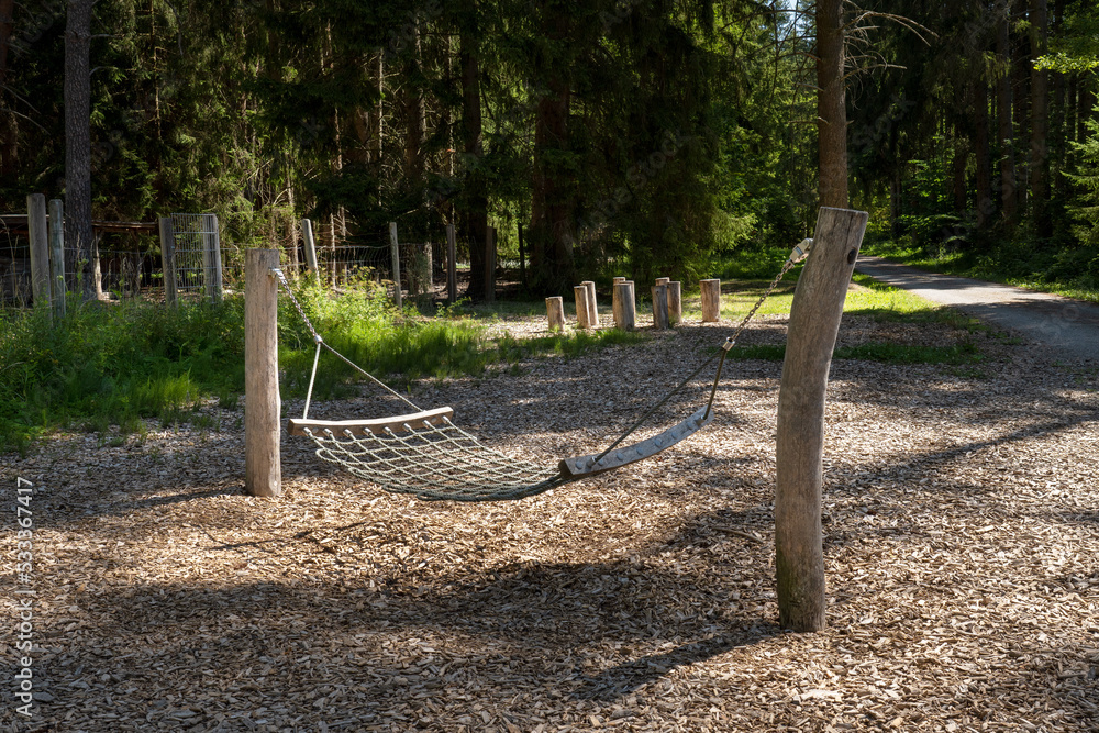 Hängematte - Liegeschaukel aus Holz und Seilen auf einem Spielplatz im Wald Hängematte - Liegeschaukel aus Holz und Seilen auf einem Spielplatz im Wald