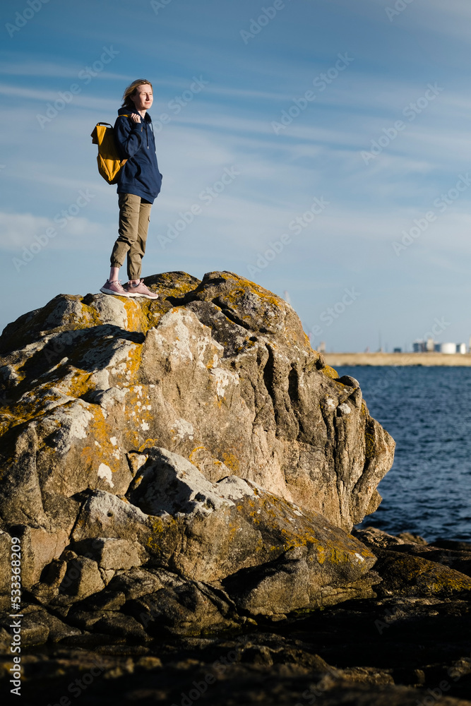 A female tourist standing on the coastal ocean cliffs. A female tourist standing on the coastal ocean cliffs.
