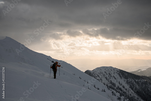 rear view of male tourist who is walking along snow-covered mountain