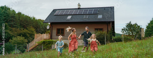 Foto Happy family running near their house with solar panels