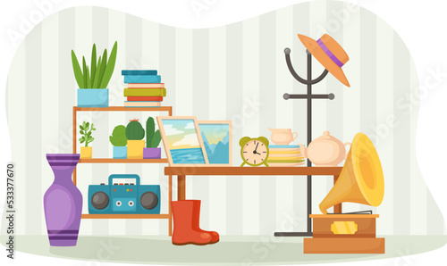 Garage sale with furniture objects, books, houseplants and old appliances