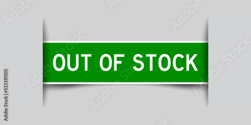 Inserted green color label sticker with word out of stock on gray background