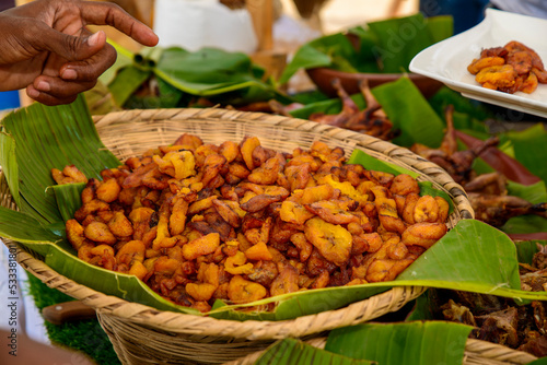 african food in banana leaves, chicken, fries photo