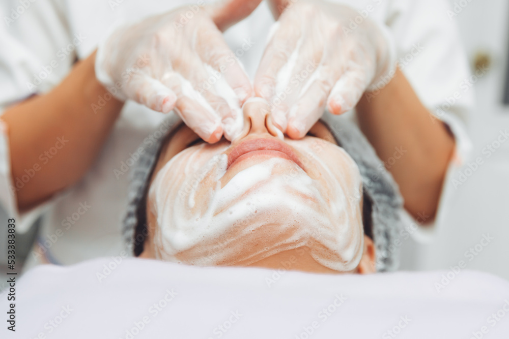 the cosmetologist cleanses the skin with foam. A woman's skin care procedure. Natural cosmetics. A beautiful face. Cosmetic treatment of the face. Therapeutic peeling cream. the cosmetologist cleanses the skin with foam. A woman's skin care procedure. Natural cosmetics. A beautiful face. Cosmetic treatment of the face. Therapeutic peeling cream.
