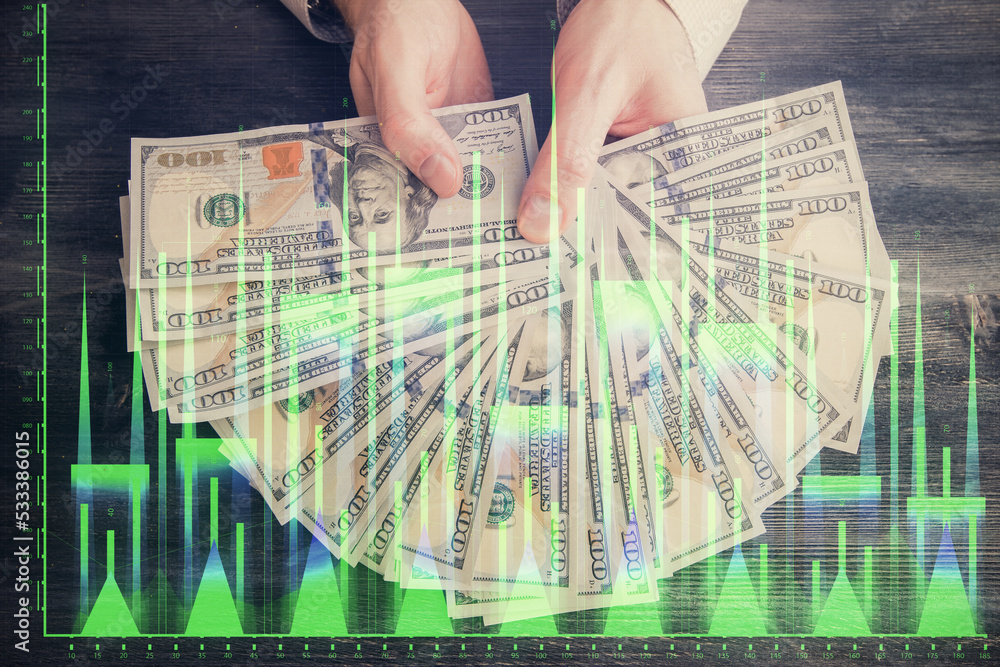 Multi exposure of financial graph drawing hologram and USA dollars bills and man hands. Analysis concept. Multi exposure of financial graph drawing hologram and USA dollars bills and man hands. Analysis concept.