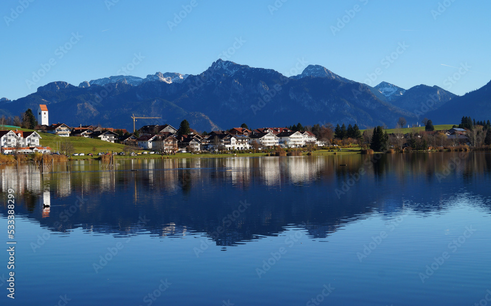 scenic and serene alpine lake Hopfensee in Schwangau with the Bavarian Alps in the background on a sunny November day (Allgaeu, Bavaria, Germany)