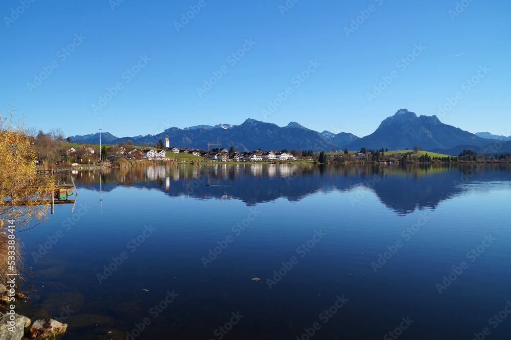scenic landscape with serene alpine lake Hopfensee in Schwangau and the Bavarian Alps in the background on a sunny November day (Allgaeu, Bavaria, Germany)