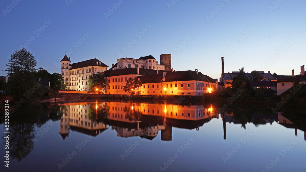 Jindrichuv Hradec Castle and Chateau, beautiful landmark mirroring in pond during night after sunset, popular tourist destination Jindrichuv Hradec, Czechia