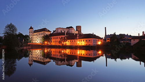 Jindrichuv Hradec Castle and Chateau, beautiful landmark mirroring in pond during night after sunset, popular tourist destination Jindrichuv Hradec, Czechia