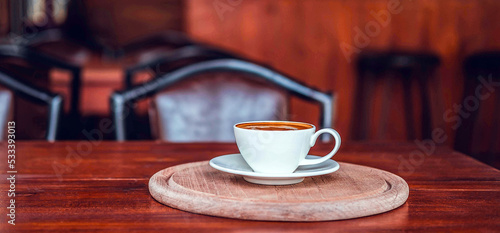 A cup of coffee on wooden table in coffee shop