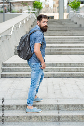 bearded man with backpack. full length of man with beard. brutal man outdoor