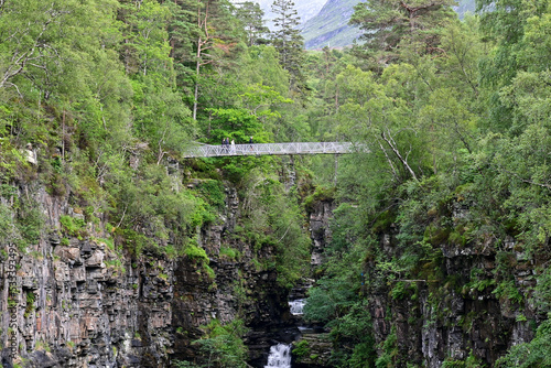 Suspension bridge over the gorge at the Falls Of Measach waterfall near Braemore, Highland, Scotland photo