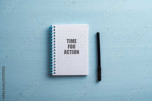 Spiral notebook with a Time for action sign spelled in it