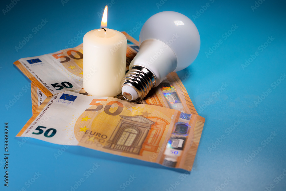 Energy price increase. Burning candles with an incandescent bulb on euro money. Increase in energy bill prices. Energy price increase. Burning candles with an incandescent bulb on euro money. Increase in energy bill prices.