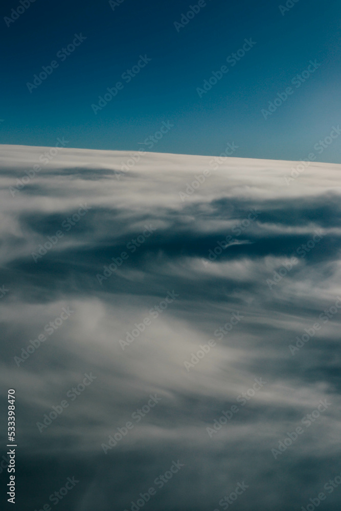 Obraz premium View over the clouds. Cloud cover seen from an airplane. Beautiful sunset sky above clouds. Beautiful orange and pink sunrise over the clouds