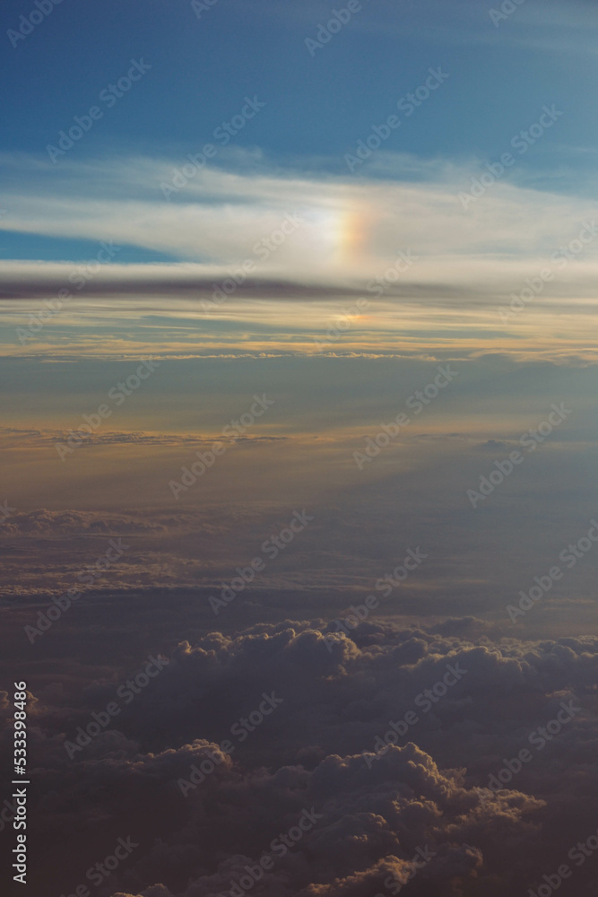 View over the clouds. Cloud cover seen from an airplane. Beautiful sunset sky above clouds.  Beautiful orange and pink sunrise over the clouds