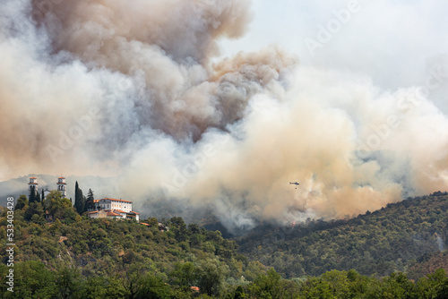 Helicopter against wildfire during strong wind and drought near Miren Castle in Slovenia