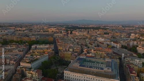 Forwards fly above classic town development in urban borough in sunset time. Streets and buildings in Esquilino borough. Rome, Italy photo