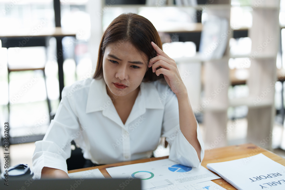 Portrait of sme business owner, woman using computer and financial statements Anxious expression on expanding the market to increase the ability to invest in business Portrait of sme business owner, woman using computer and financial statements Anxious expression on expanding the market to increase the ability to invest in business