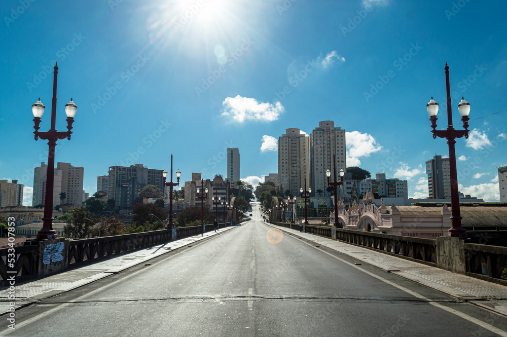 Sun in blue sky with few clouds at Santa Tereza viaduct in the city of Belo Horizonte. Old lampposts.