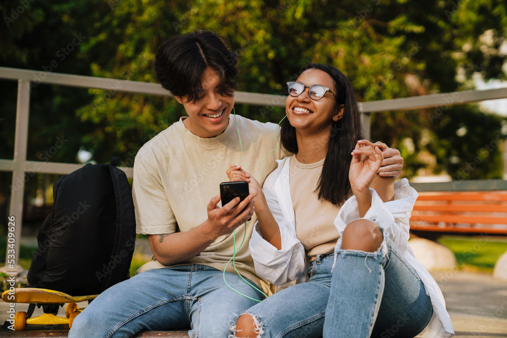 Young handsome smiling asian boy hugging beautiful happy african girl Young handsome smiling asian boy hugging beautiful happy african girl