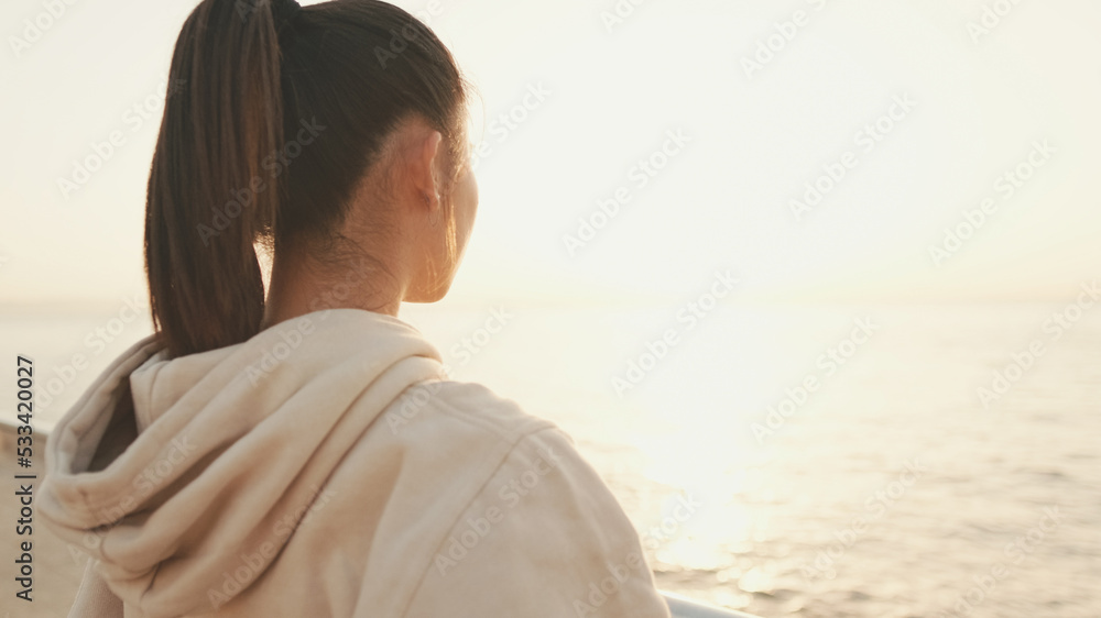 Close up, asian girl in sportswear stands at morning time on the sea background