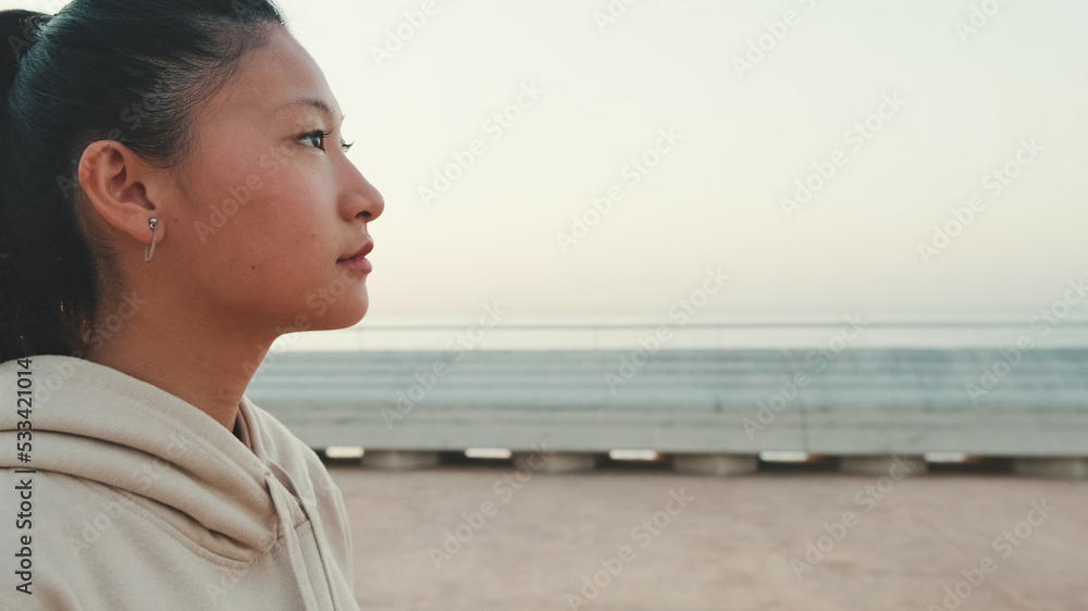 Close-up profile asian girl wears sportswear walking outside at morning time Close-up profile asian girl wears sportswear walking outside at morning time