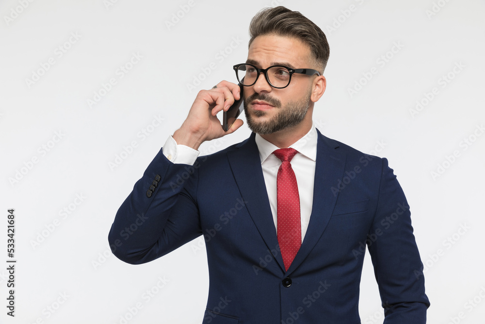 busy businessman with glasses talking on the phone and looking away busy businessman with glasses talking on the phone and looking away