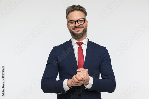 proud young man with red tie and glasses holding hands together