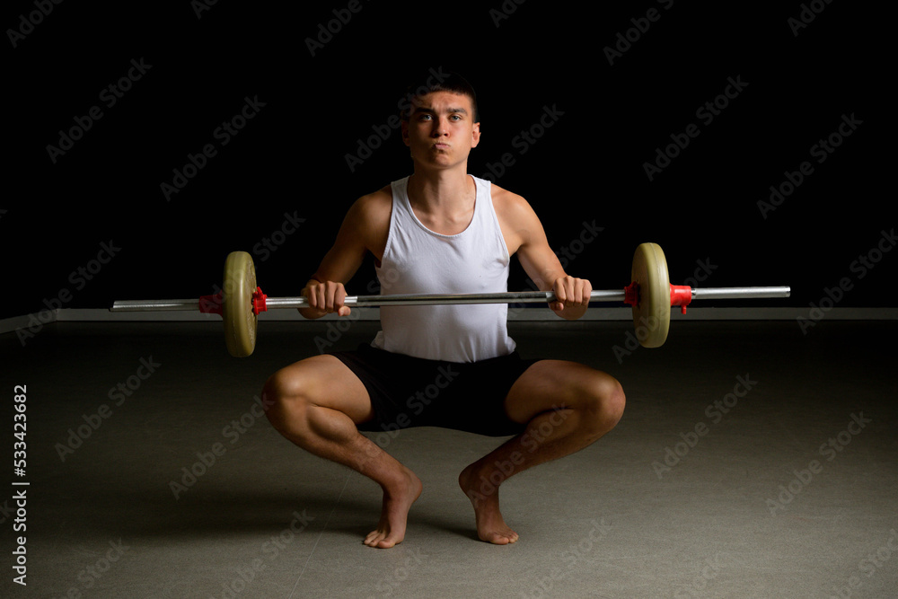 Nineteen year old teen boy exercising with a barbell Nineteen year old teen boy exercising with a barbell